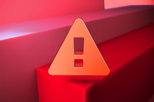 赤い背景の前にある注意マーク