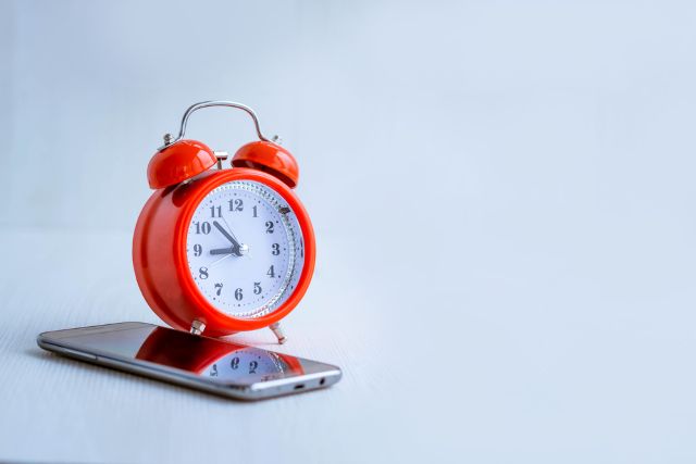 携帯の上に置かれた時計